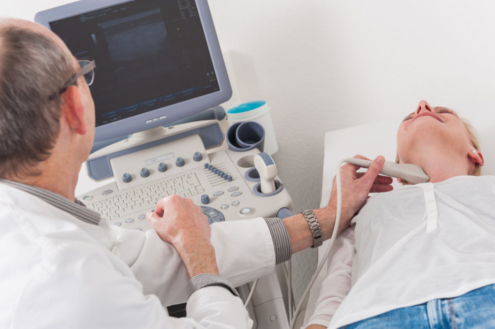 Arzt führt einen Ultraschall bei Patientin durch.